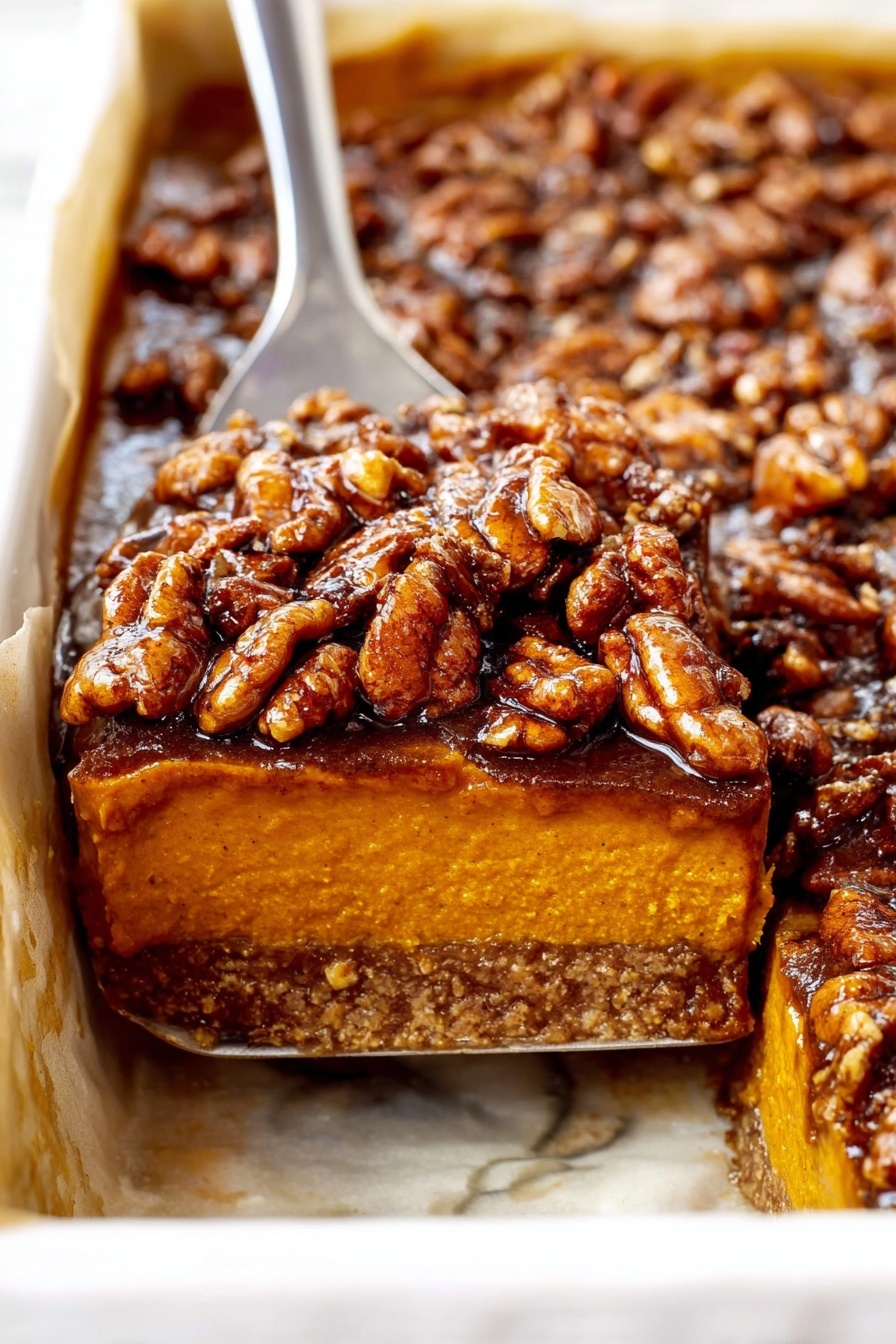A close-up of a three-layer dessert square on a white plate with a white marbled texture beneath it. The bottom layer is a thin, crumbly crust in a light brown color. The middle layer is thick, smooth, and creamy with a rich pumpkin orange color and soft texture. The top layer is a thick pile of chopped pecans, glossy and dark brown, coated in a sticky syrup that makes them shine. Some small pieces of pecans are scattered on the plate around the dessert. In the background, there are blurred white pumpkins. Photo taken with an iphone --ar 2:3 --v 7