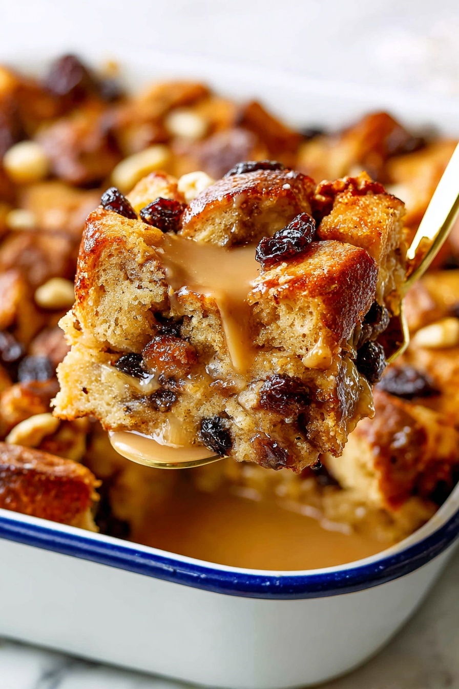 The image shows a close-up of a golden brown bread pudding slice being lifted with a gold spatula. The bread pudding has several layers of unevenly shaped bread pieces with a slightly crispy texture on top, mixed with dark raisins and lighter nut pieces scattered throughout. A smooth, light caramel sauce glistens over the top, adding shine and moisture. The bread pudding sits inside a white baking dish with a blue rim, placed on a white marbled surface. The scene is bright and detailed, highlighting the moist and textured layers of the dessert. Photo taken with an iphone --ar 2:3 --v 7