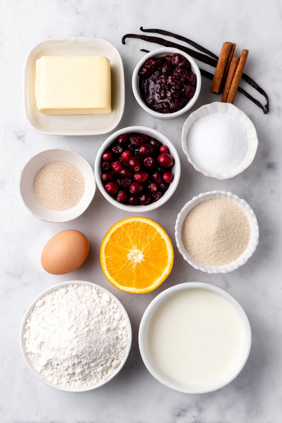 Flat lay of a stick of unsalted butter softened, a small heap of light brown sugar, a small heap of granulated sugar, a single large whole egg with a clean shell, a few whole vanilla beans, a simple mound of all-purpose flour, a small pile of ground cinnamon powder, a small pile of baking powder, a small pinch of kosher salt, fresh bright red cranberries, a small white ceramic bowl with granulated sugar, a small white ceramic bowl with cornstarch, fresh orange with a few thin strips of orange zest and a small white ceramic bowl holding fresh orange juice, a small white ceramic bowl of powdered sugar, a small white ceramic bowl of whole milk, all arranged symmetrically with perfect spacing, placed on a clean white marble surface, soft natural light, photo taken with an iPhone, professional food photography style, fresh ingredients, white ceramic bowls, no bottles, no duplicates, no utensils, no packaging --ar 2:3 --v 7 --p m7354615311229779997