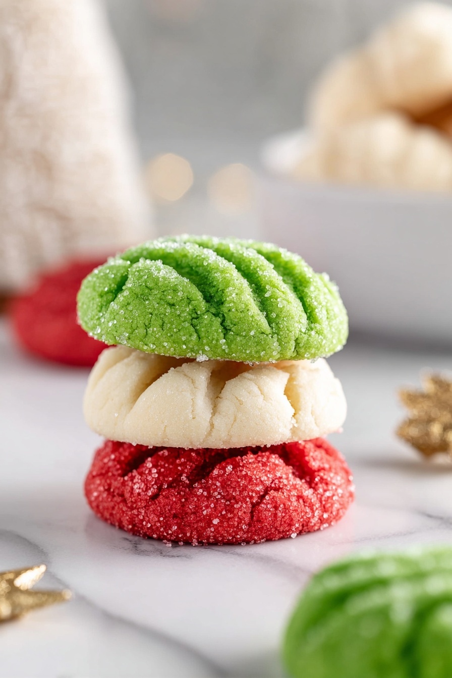 The image shows a white bowl filled with round cookies in three colors: red, green, and white. Each cookie has four parallel lines pressed into its top surface and is lightly covered with granulated sugar, giving a sparkling texture. Around the bowl on a white marbled surface, there are several more cookies scattered in the same colors and style. In the background, another white plate holds a few more cookies. To the left of the bowl, there are small decorative Christmas trees in green, white, and gold, adding a festive touch. photo taken with an iphone --ar 2:3 --v 7