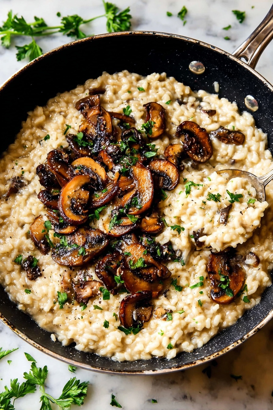 A black pan filled with creamy beige risotto mixed with small visible grains, topped with dark brown sautéed mushroom slices scattered all over the dish, with bright green parsley pieces sprinkled on top for color contrast. There is a spoon lifting some risotto near the right side of the pan. The pan is placed on a white marbled surface with a few parsley leaves around it. Photo taken with an iphone --ar 2:3 --v 7
