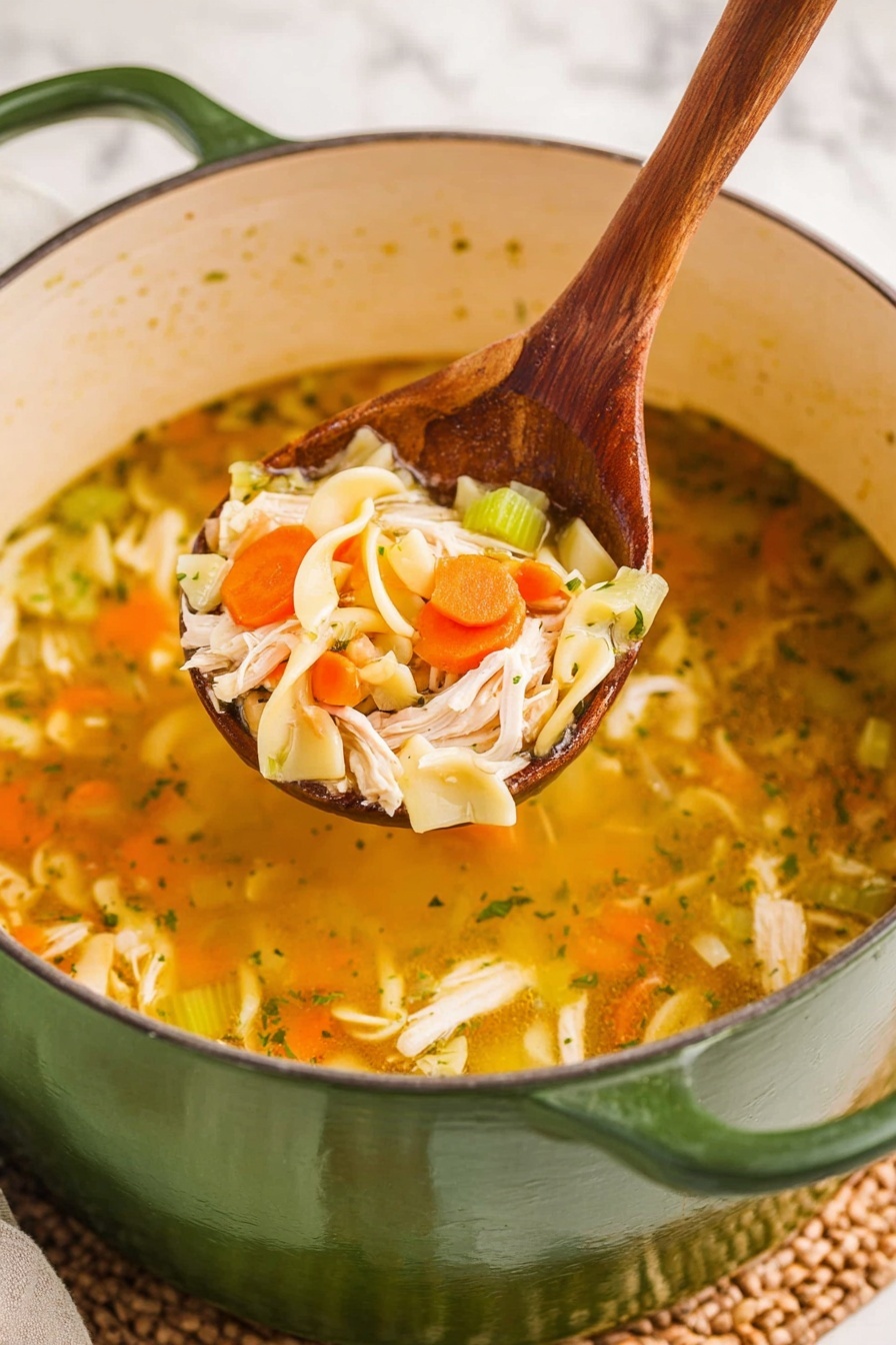 A large green pot filled with clear golden broth soup, showing layers of soft, orange carrot slices, small chunks of white chicken, light green celery pieces, and pale yellow curly pasta noodles. A wooden spoon lifts a mix of these ingredients above the soup, highlighting the chunky textures of the carrots, chicken, celery, and pasta. The background surface is a white marbled texture with a woven mat partially visible under the pot. Photo taken with an iphone --ar 2:3 --v 7
