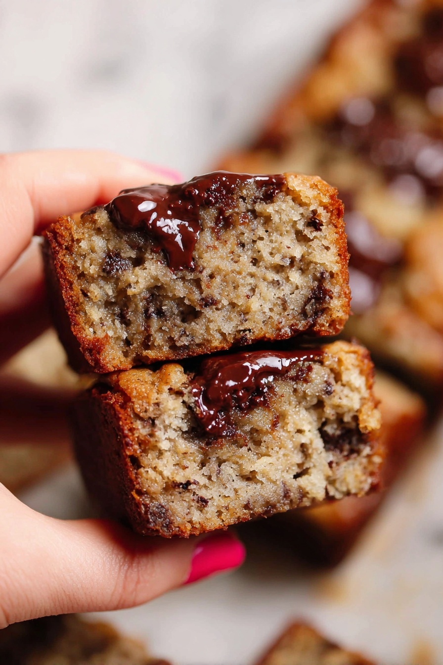 A white bowl filled with thick, shiny batter that has a light brown color with small lumps and darker specks throughout. The batter looks smooth but textured, showing a mix of wet and dry parts evenly combined. A white spatula with a wooden handle is resting inside the bowl on the right side, partially dipped in the batter. The bowl is placed on a white marbled surface. photo taken with an iphone --ar 2:3 --v 7