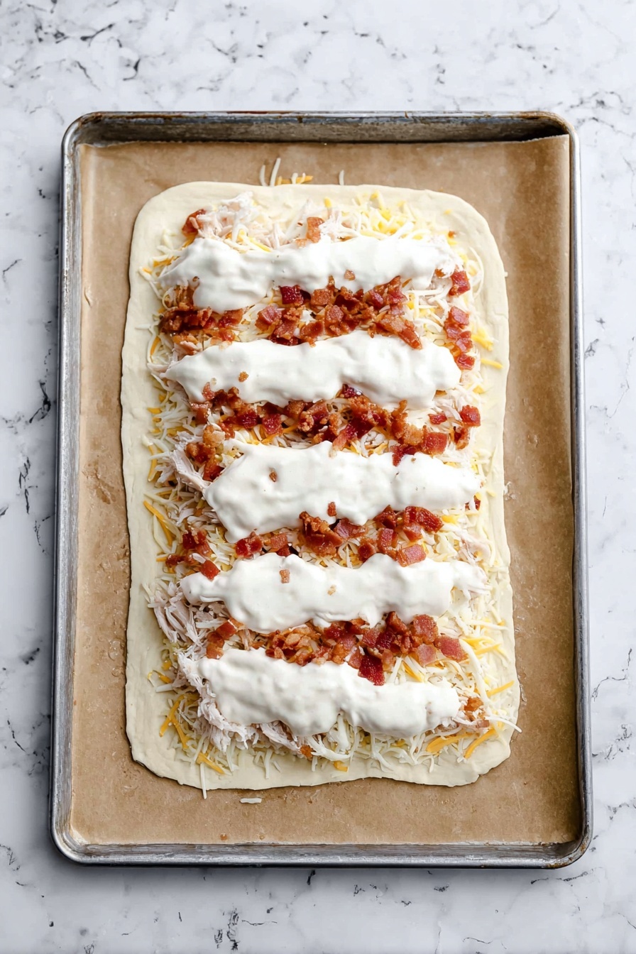 The image shows several slices of a stuffed bread, each piece cut to reveal three layers inside: a soft white dough outer layer, a creamy white cheese mix middle layer mixed with small pieces of cooked chicken, and bits of reddish-brown bacon sprinkled throughout. The bread crust is golden brown and slightly crispy, surrounding the creamy filling. Small green herb flecks are scattered on the top of the cheese layer. A small white bowl filled with white dipping sauce is placed near the bread slices, all on a white marbled surface. Photo taken with an iphone --ar 2:3 --v 7